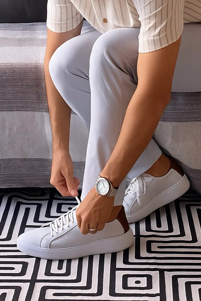 homem amarrando tenis casual branco