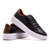 tenis casual preto mostrando detalhe marrom atrás